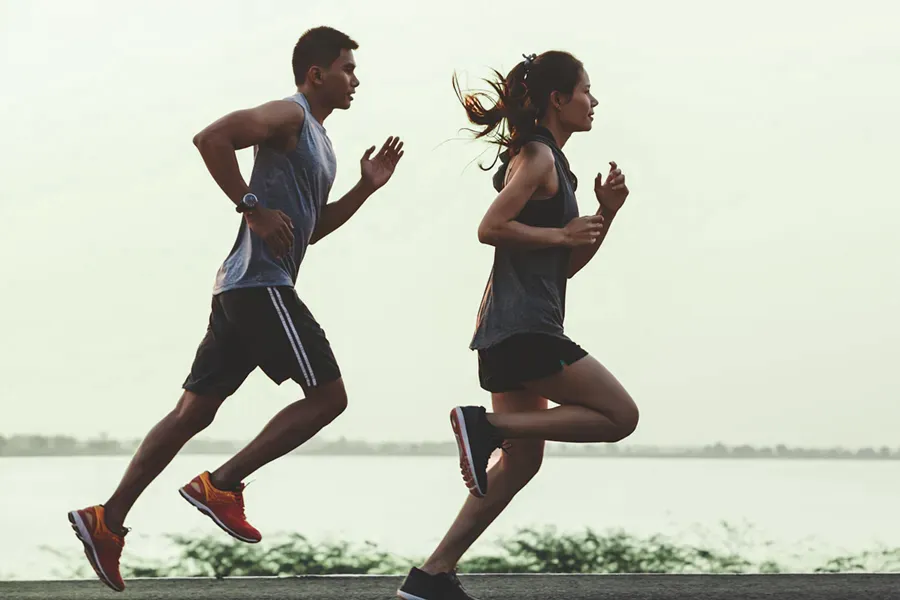 A couple in profile running along the water. Schedule GLP-1 Weight Loss Injections from Balanced Medical Solutions in San Francisco Bay Area.