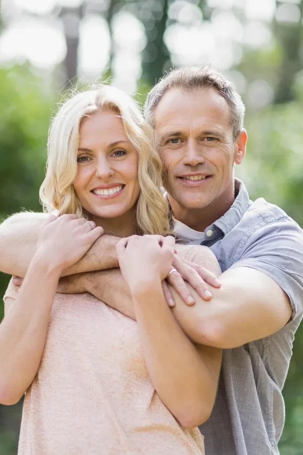 A middle-aged couple embrace outdoors on a sunny day. Get HGH hormone therapy from Balanced Medical Solutions in San Francisco Bay Area.