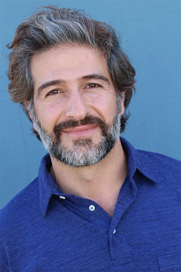 Hair-Loss-Treatment Image of a cheerful man with a bright smile and curly hair against a natural landscape. Balanced Medical Solutions provides personalized hair loss treatments in San Francisco Bay Area.