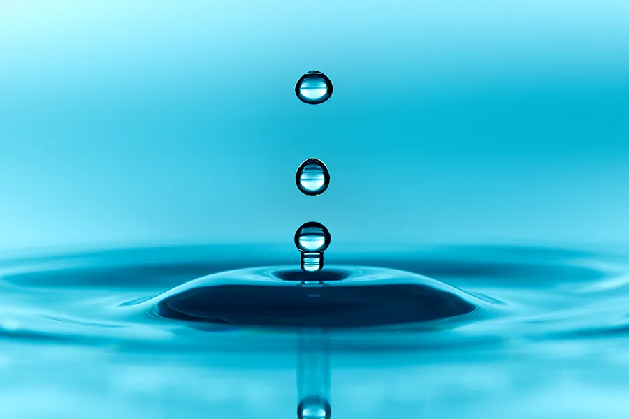 Close-up of water dripping into a blue pool making ripples. Schedule methylene blue IV therapy from Balanced Medical Solutions in San Francisco Bay Area.