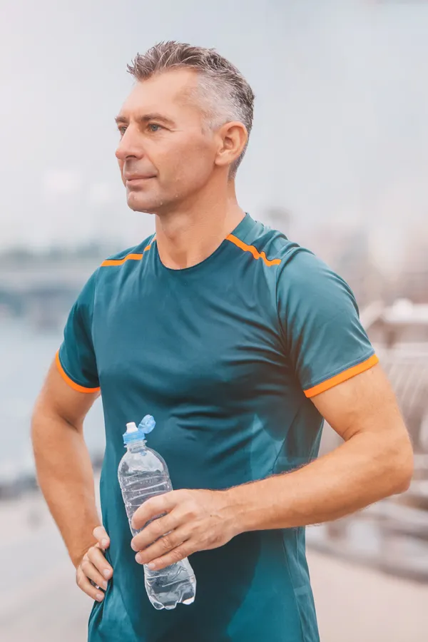 A middle-aged man rehydrates after a hard workout. Get plaquex IV therapy from Balanced Medical Solutions in San Francisco Bay Area.