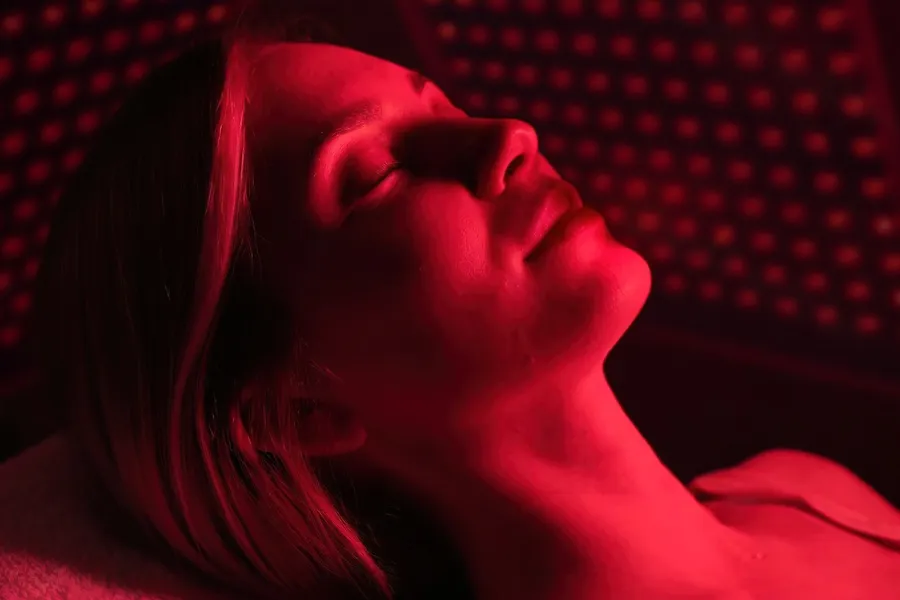 A woman lies in a red light therapy device. Get red light therapy from Balanced Medical Solutions in San Francisco Bay Area.