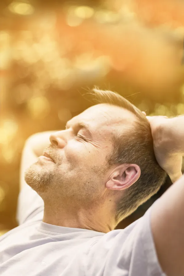 A man relaxes in the sun. Get red light therapy from Balanced Medical Solutions in San Francisco Bay Area.