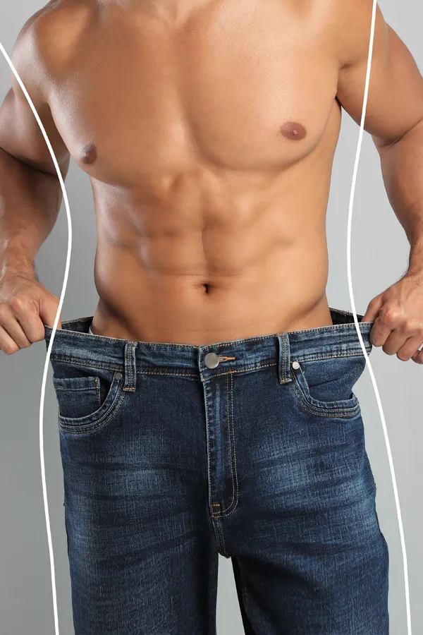 Semaglutide-Weight-Loss-Treatment A strong shirtless man in jeans holds the waistlines of his too-big jeans to show the success of semaglutide weight loss from Balanced Medical Solutions in San Francisco Bay Area.