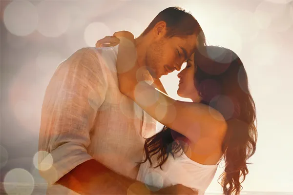 Sexual-Wellness-for-Women-and-Men-Doctor A couple in linen shirts standing in a sparkling light embraces each other with their foreheads touching and eyes closed, happy with their sexual wellness treatments from Balanced Medical Solutions in San Francisco Bay Area.