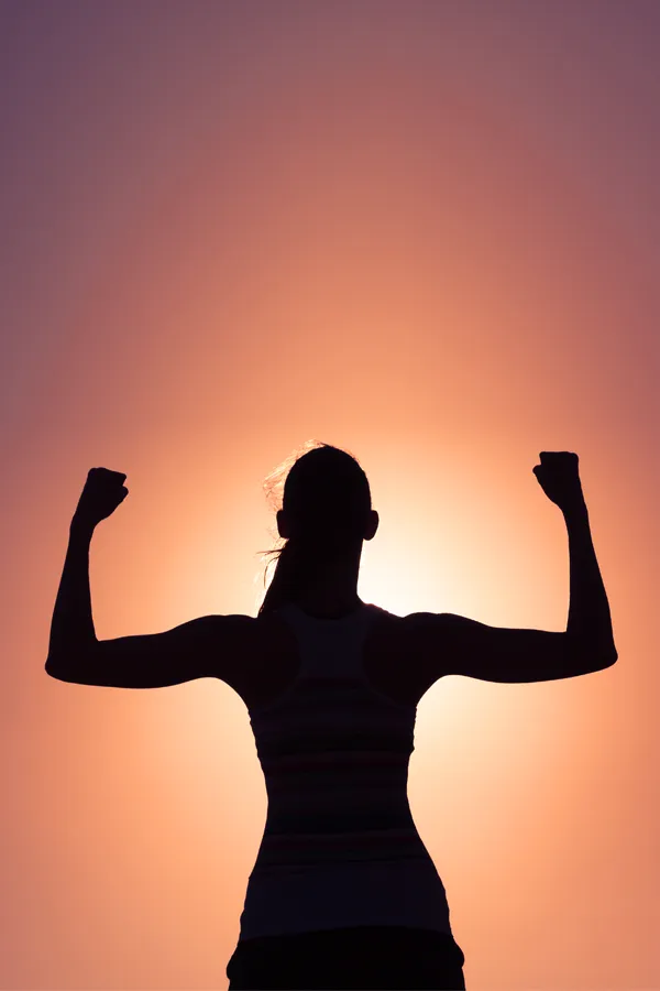 A woman silhouetted by the sunset flexes her strong arms. Get Stem Cell IV Therapy from Balanced Medical Solutions in San Francisco Bay Area.
