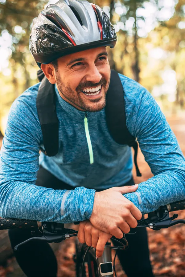 Testosterone-Low-T-Solutions-Treatment A middle-aged man on a trail in cycling clothes is smiling and leaning on his bike's handlebars. Get testosterone for Low T from Balanced Medical Solutions in San Francisco Bay Area.